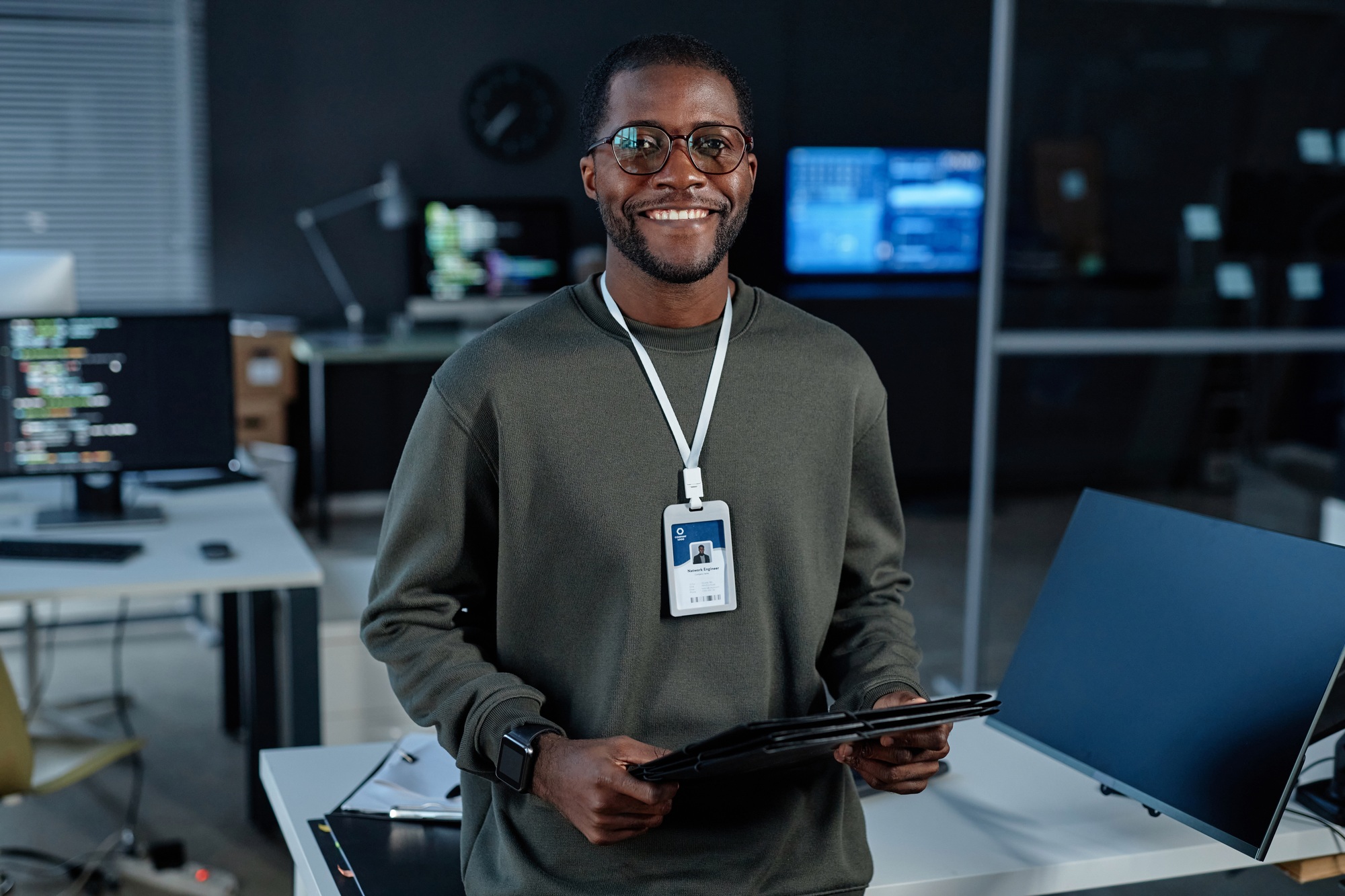 Black Young Man Smiling at Camera in Cybersecurity Office